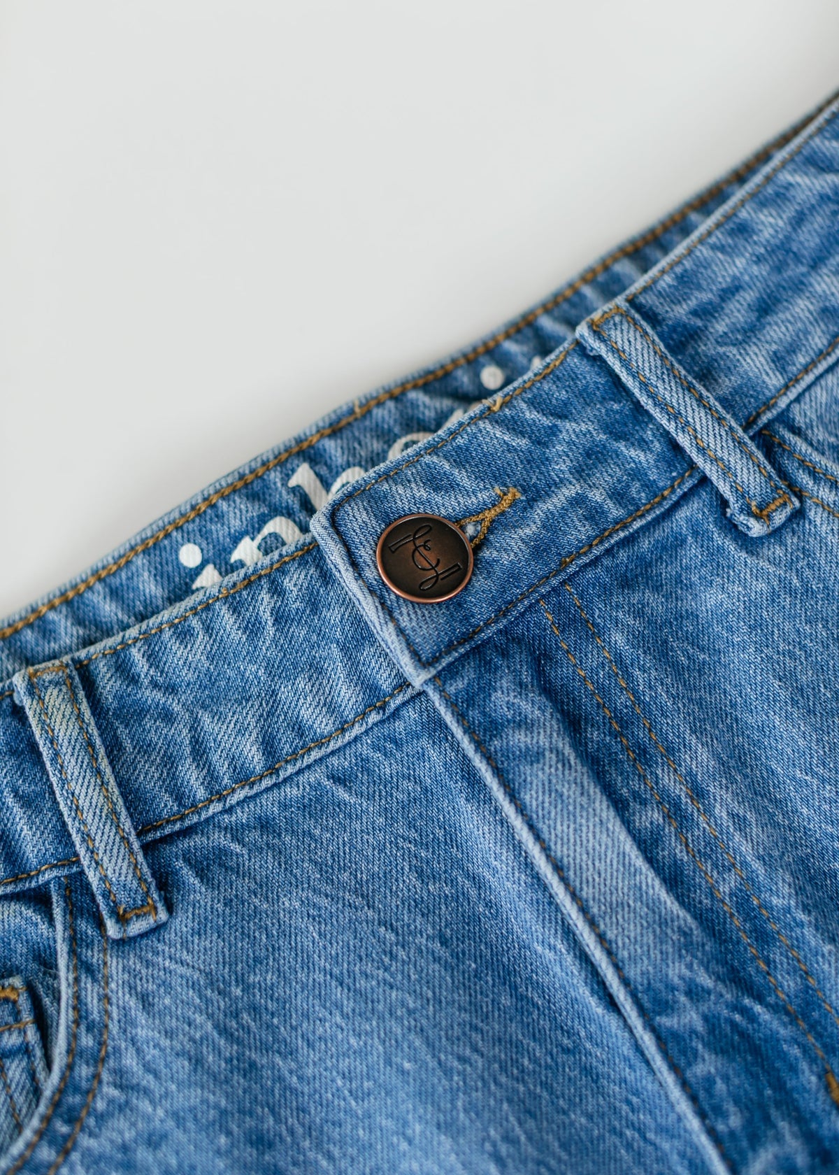 Inherit Co. Remi Denim Classic Wash Midi Skirt, featuring a mid-length design with a timeless denim look and subtle stitching details.