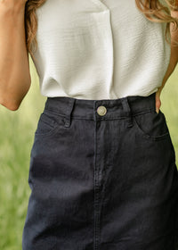 Navy denim midi skirt by Inherit Co. from IC Skirts collection, shown with a flowy, mid-length design and classic denim texture.