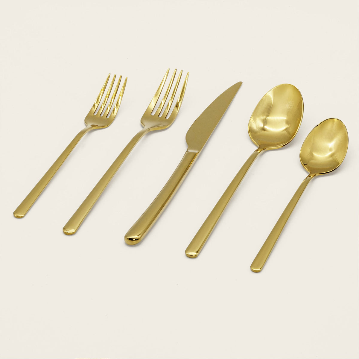 Italic Emilia Mirror 20-piece gold flatware set with sleek, modern design and polished finish on stainless steel utensils.