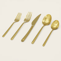 Italic Emilia Mirror 20-piece gold flatware set with sleek, modern design and polished finish on stainless steel utensils.