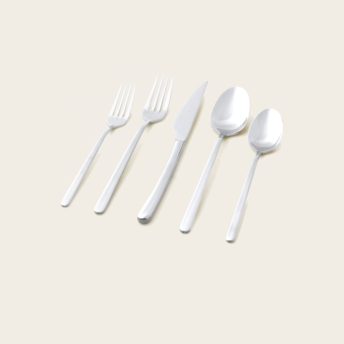 Italic Emilia Mirror 20-piece gold flatware set with sleek handles and polished finish, including forks, knives, spoons, and teaspoons.