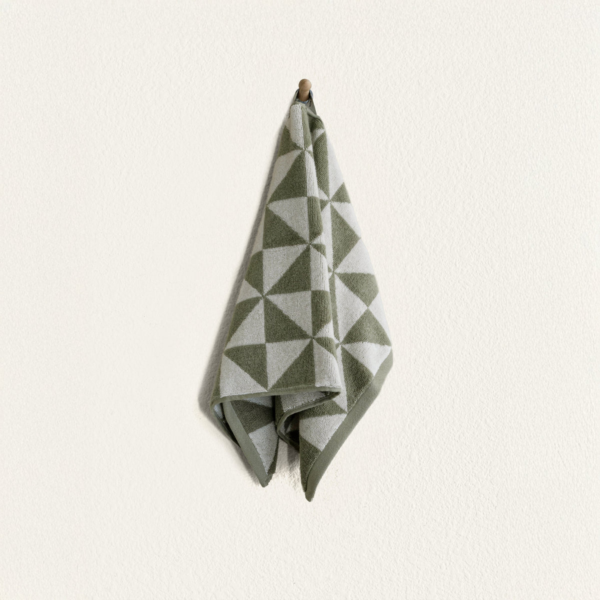 Set of two Italic Umbra bath towels in sage and ecru, soft and plush for home use, shown with one washcloth in matching colors.
