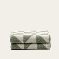 Set of two Italic Umbra bath towels in sage and ecru, soft and plush for home use.