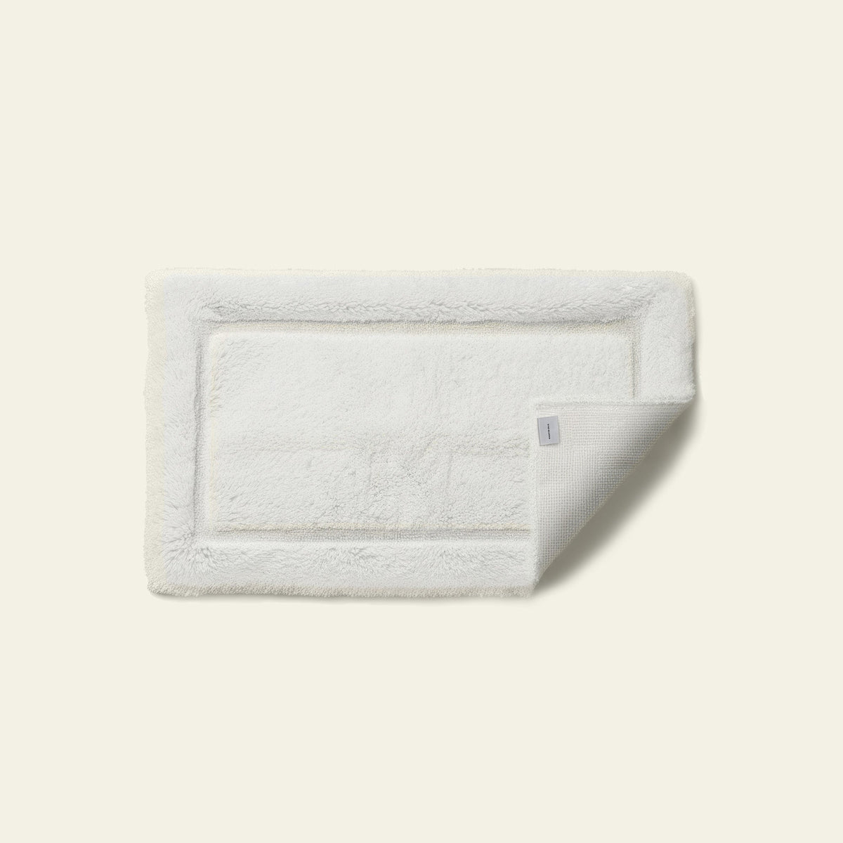 White Italic Ultraplush skid-resistant bath mat with soft, plush texture, designed for safety and comfort in the bathroom.