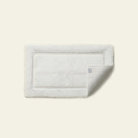 White Italic Ultraplush skid-resistant bath mat with soft, plush texture, designed for safety and comfort in the bathroom.
