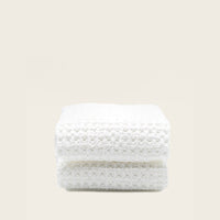 Set of two white Sedona Waffle Towels for home bath from Italic, featuring textured waffle fabric, displayed on a bathroom background.