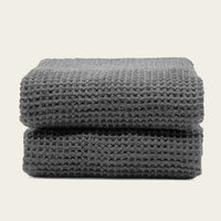 Set of two white Sedona Waffle Towels by Italic, plush bath towels with a textured waffle weave, shown folded on a white background.