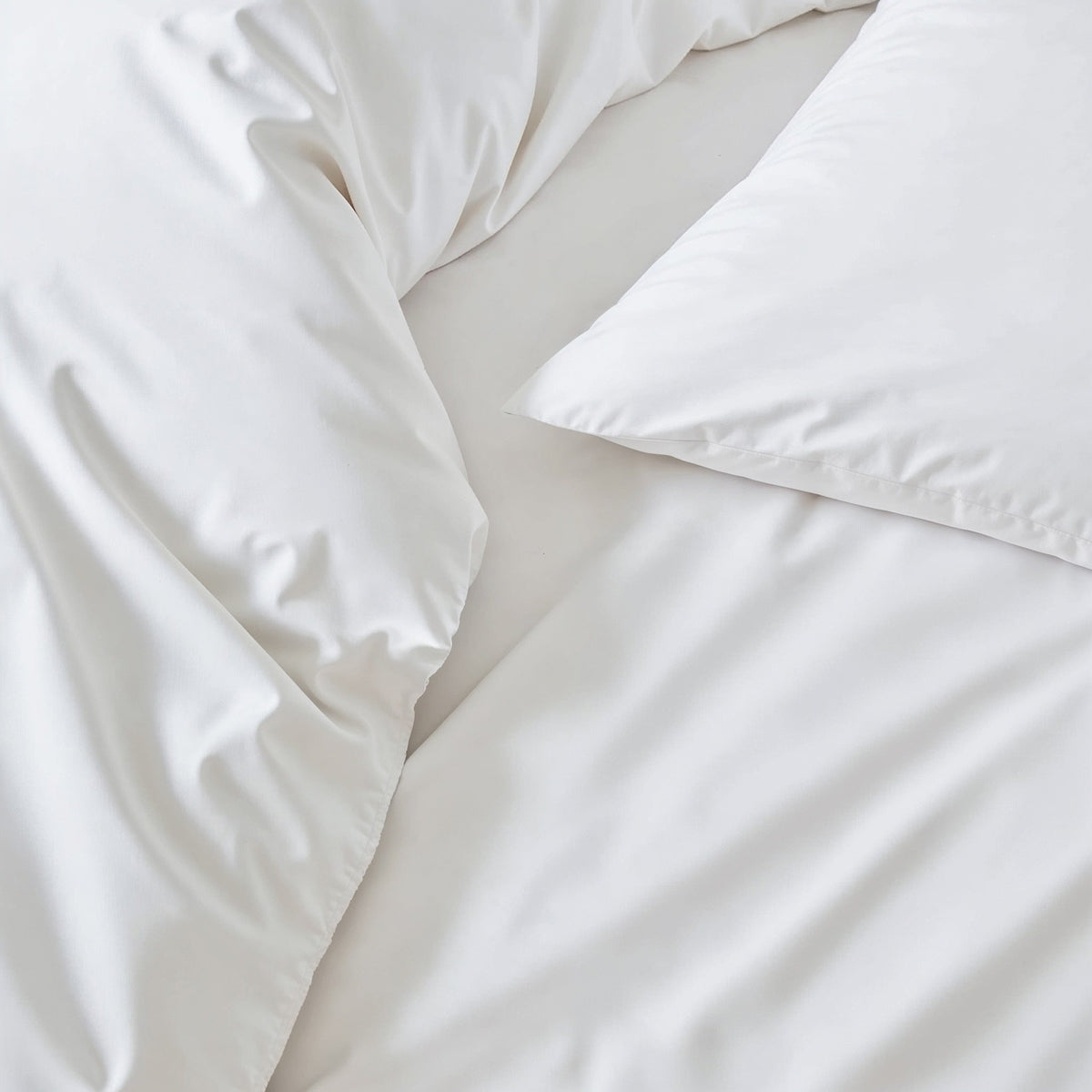 Blue and white Luxe Australian Sateen Bedding Bundle by Italic on a bed, showcasing soft, luxurious satin fabric in a twin size.