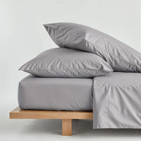 Blue and white Luxe Australian Sateen Bedding Bundle by Italic on a twin bed, featuring smooth, luxurious satin bedding.
