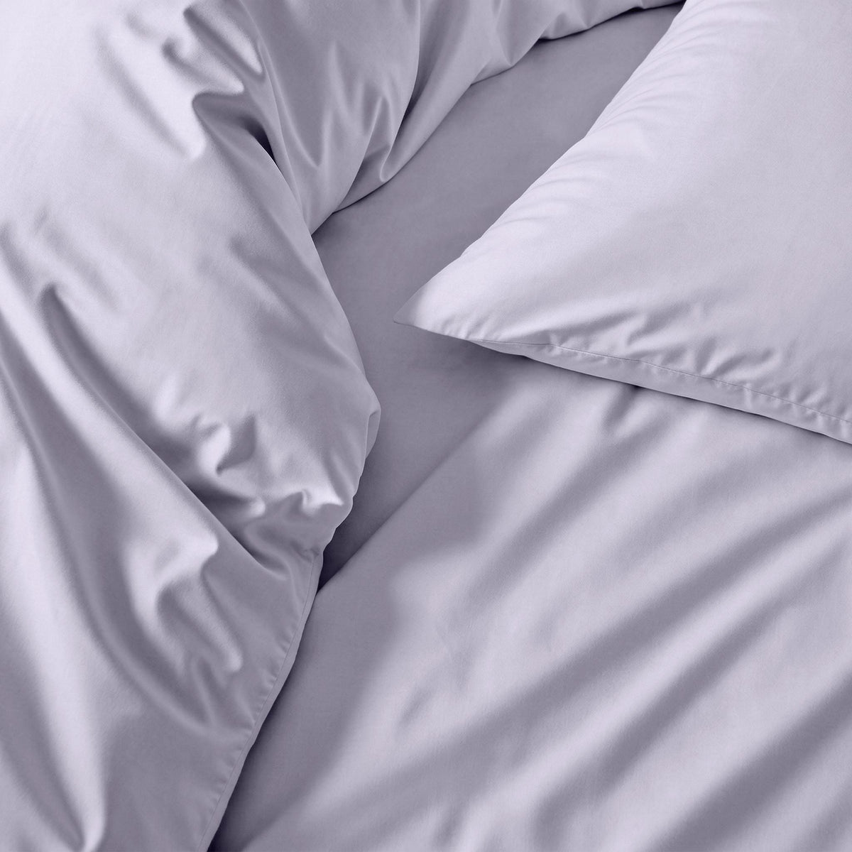 Blue and white Luxe Australian Sateen Bedding Bundle by Italic on a twin bed, showcasing smooth, luxurious satin fabric.