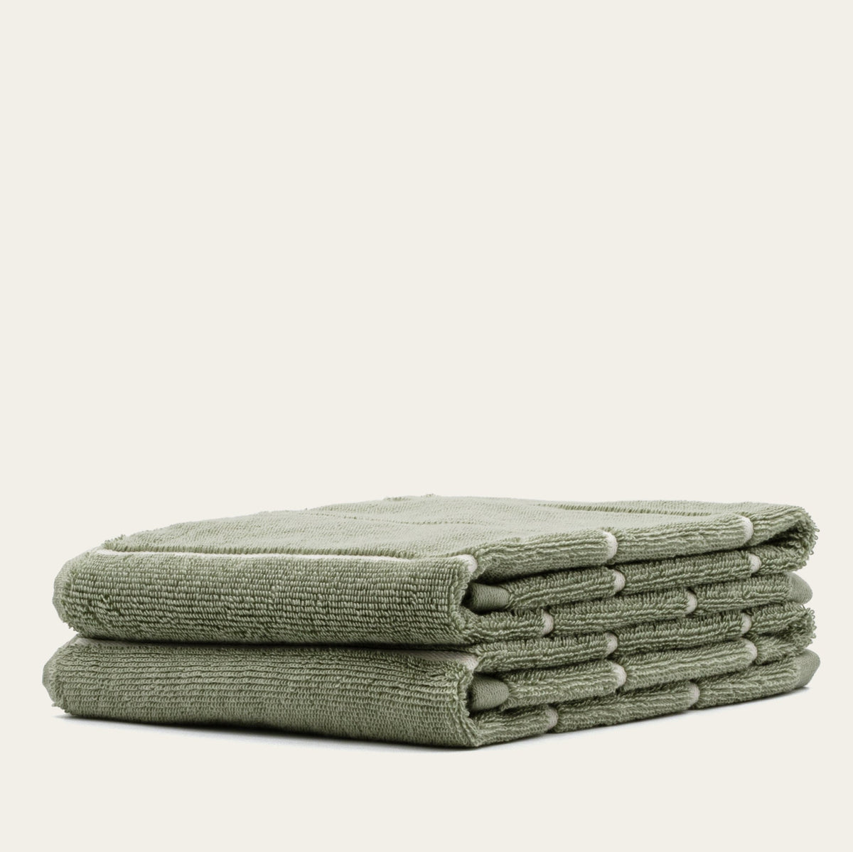 Set of two Italic Deia sage and ecru bed towels featuring soft, plush fabric for home use.