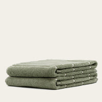 Set of two Italic Deia sage and ecru bed towels featuring soft, plush fabric for home use.