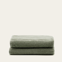 Set of two Italic Deia bed towels in sage and ecru, soft and plush home textiles for a cozy bedroom setting.