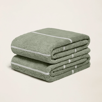 Set of two Italic Deia sage and ecru bed towels featuring soft, plush fabric for home bedding comfort.