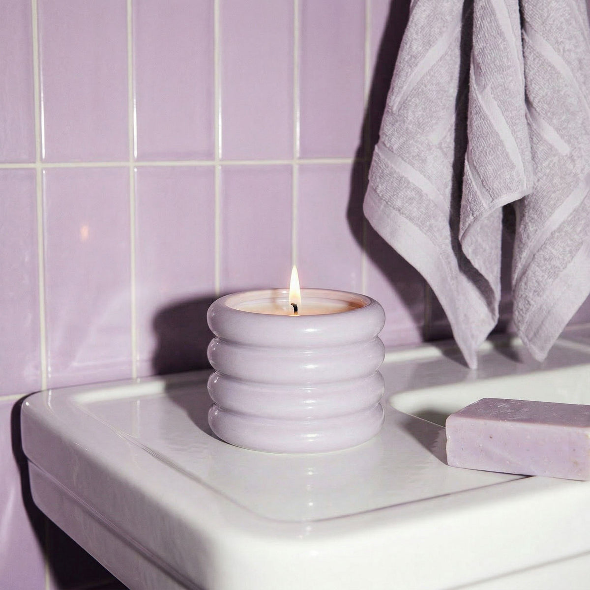 Italic Matcha Bloom ceramic candle in a decorative ceramic holder with a lit wick, showcasing a calming green design.