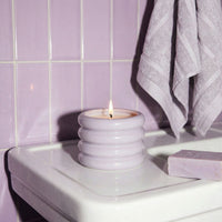 Italic Matcha Bloom ceramic candle in a decorative ceramic holder with a lit wick, showcasing a calming green design.