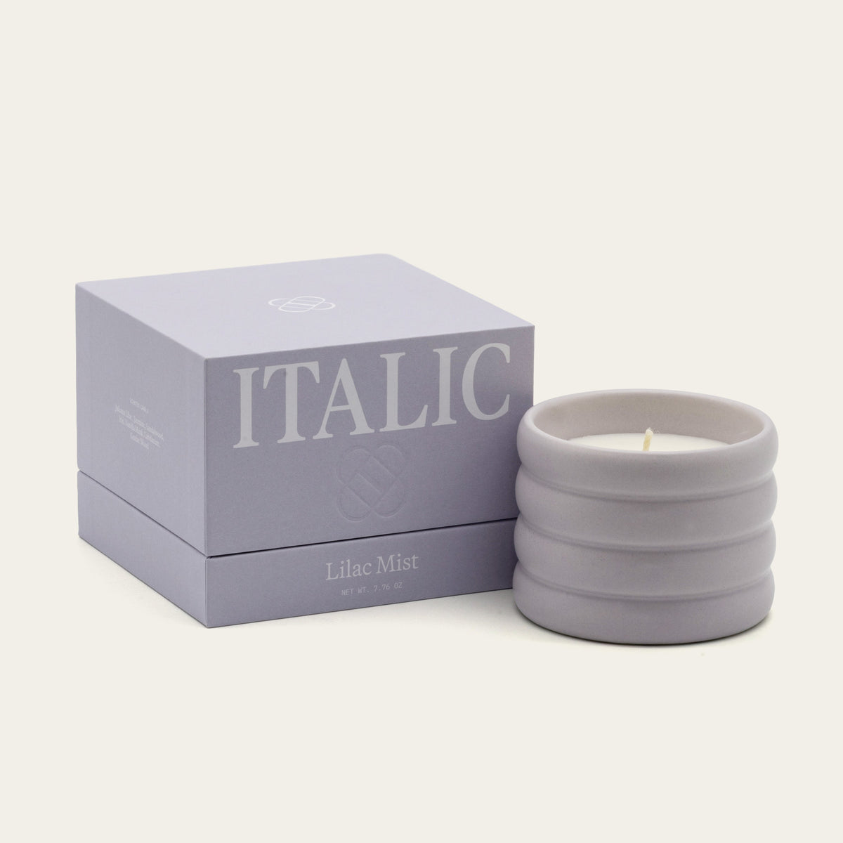 Italic Matcha Bloom ceramic candle in a white ceramic holder with a subtle floral design and a lit wick.