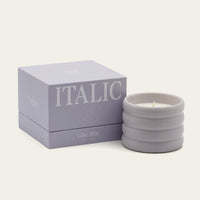 Italic Matcha Bloom ceramic candle in a white ceramic holder with a subtle floral design and a lit wick.
