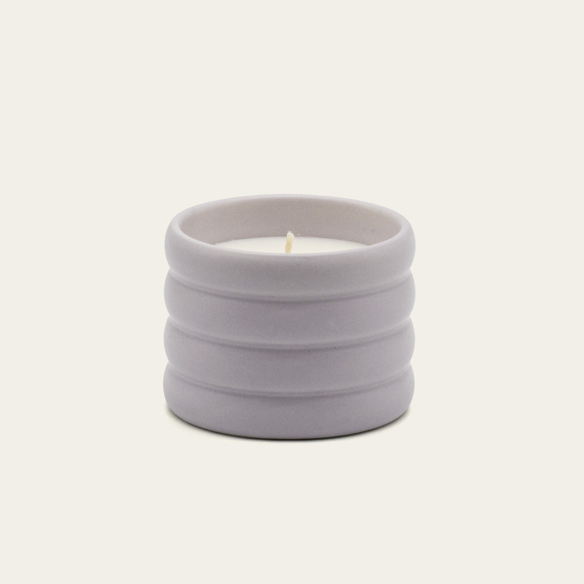 Italic Matcha Bloom ceramic candle in a white ceramic holder with a textured design and a lit wick.