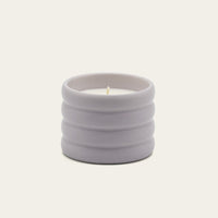 Italic Matcha Bloom ceramic candle in a white ceramic holder with a textured design and a lit wick.