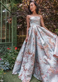 Blue Arabella Dress by JessaKae, featuring a flowing design and elegant fabric, displayed on a hanger.