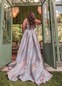 Blue Arabella Dress by JessaKae, featuring flowing fabric and elegant design, displayed on a hanger.