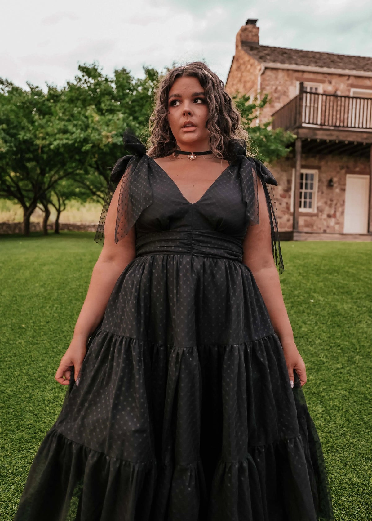 Black Jeanne Dress by JessaKae, showing a fitted dress with a scoop neckline and short sleeves on a model.