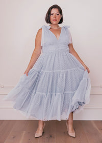 Dusty blue Jeanne Dress by JessaKae on a hanger, featuring a flowy design and elegant fabric, perfect for casual or semi-formal wear.