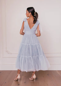 Dusty blue Jeanne Dress by JessaKae, flowing fabric, V-neckline, and long sleeves, stylish and elegant for any occasion.