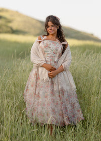 JessaKae Francesca Dress displayed on a hanger, featuring a flowy fabric, floral pattern, and elegant design.