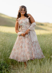 JessaKae Francesca Dress featuring a flowy silhouette, floral pattern, and sleeveless design displayed on a hanger.