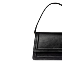 Black leather mini crossbody bag by Kila Siku featuring a sleek design and adjustable strap, perfect for everyday use.