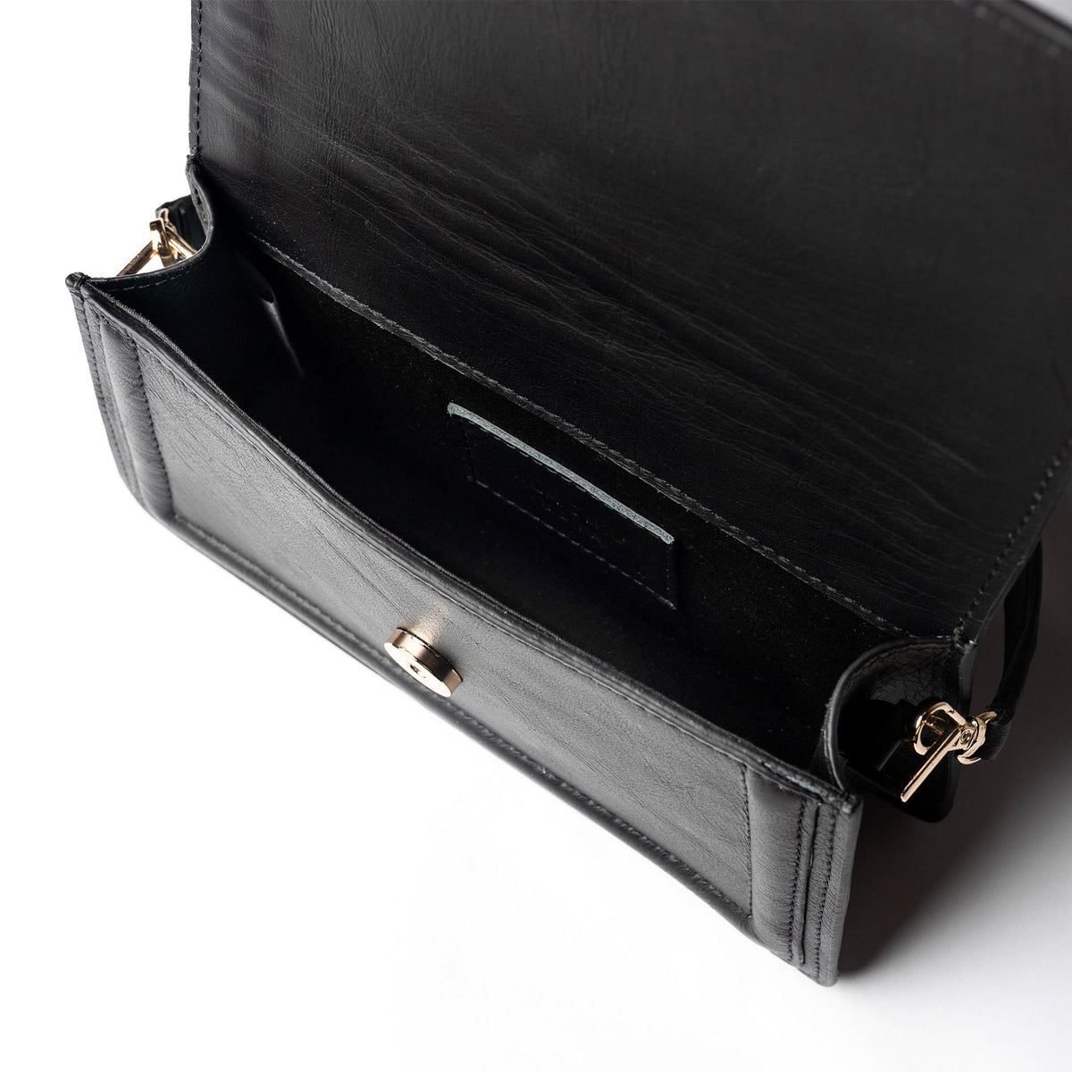 Black leather mini crossbody handbag by Kila Siku, featuring adjustable strap and compact design with gold-tone hardware.