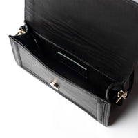 Black leather mini crossbody handbag by Kila Siku, featuring adjustable strap and compact design with gold-tone hardware.