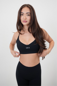 Black sports bra from KIMITH BRAND with supportive design and logo detail, suitable for workout and active wear.
