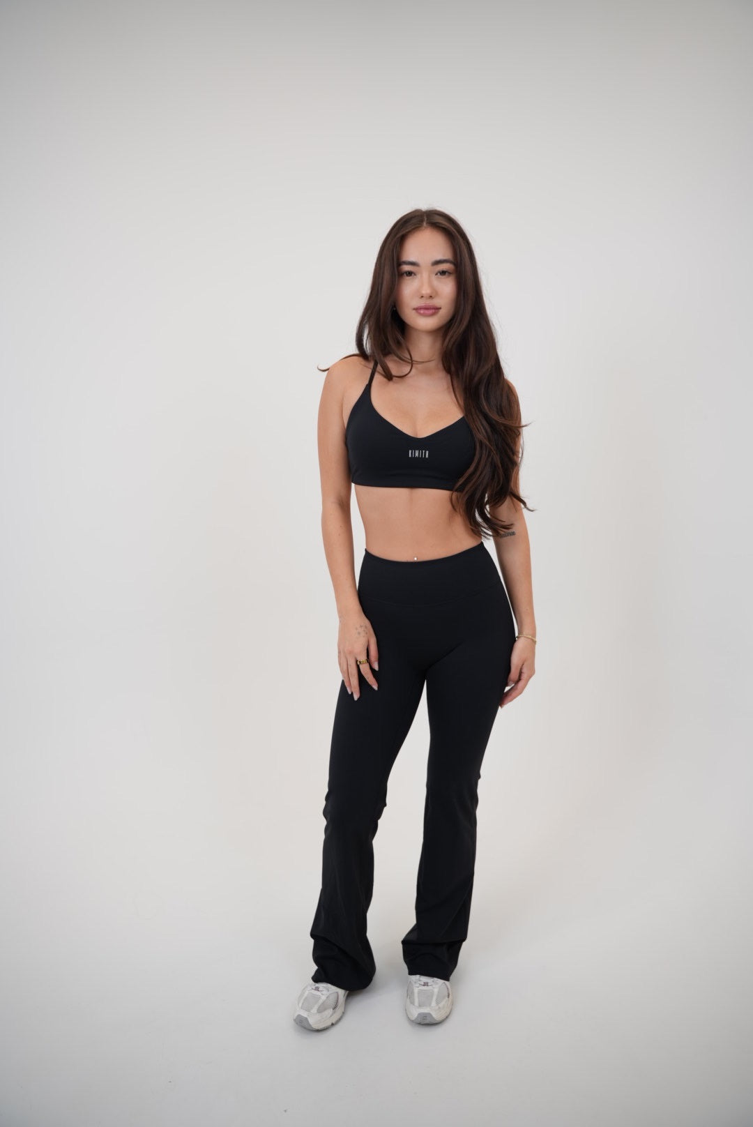 Black sports bra from KIMITH BRAND with "I Live in Luxury" slogan, featuring supportive design and comfortable fit.