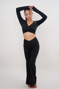 Black stretch flare legging by KIMITH BRAND, showing fitted waist and flared leg design on a model.