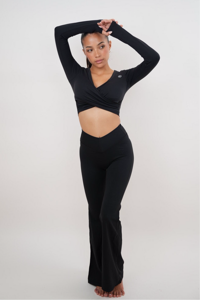Black stretch flare legging by KIMITH BRAND, showing fitted waist and flared leg design on a model.
