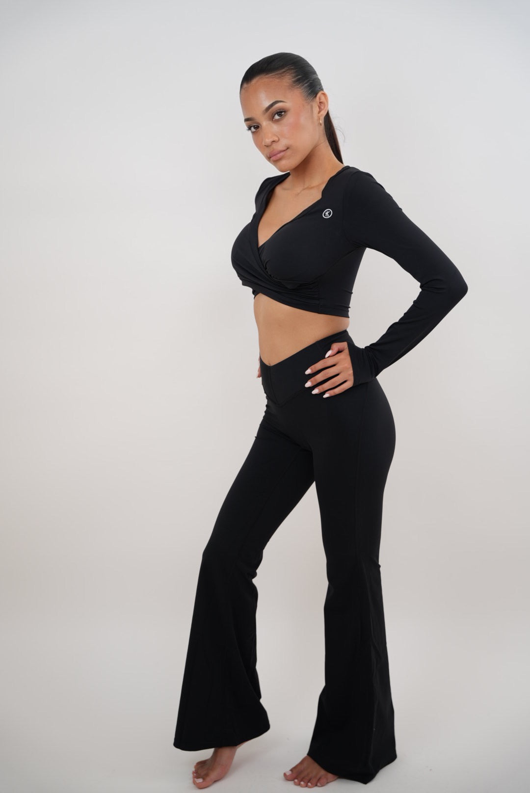 Black stretch flare legging by KIMITH BRAND featuring a fitted waist and flared leg design, shown on a person standing.