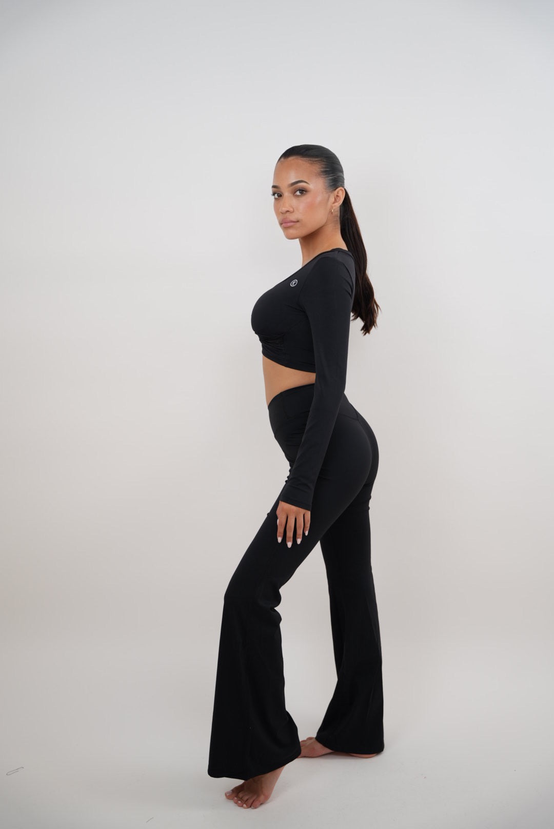 KIMITH BRAND black stretch flare leggings with high waist and fitted design, shown on a model.