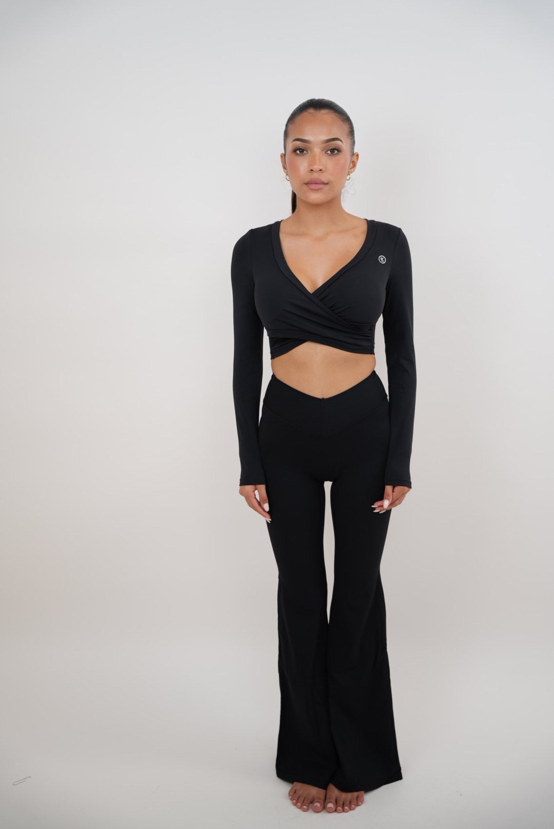 Black stretch flare legging by KIMITH BRAND featuring fitted waistband and flared leg design, shown on a model.