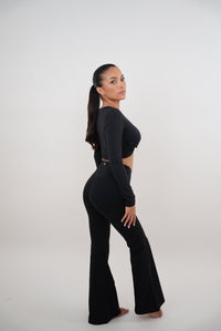 Black stretch flare legging by KIMITH BRAND, showing a close-up of the fitted waistband and flared leg design.