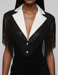 L'Jai Amor The Strategist Cape displayed on a hanger, showcasing its stylish design and fabric details.