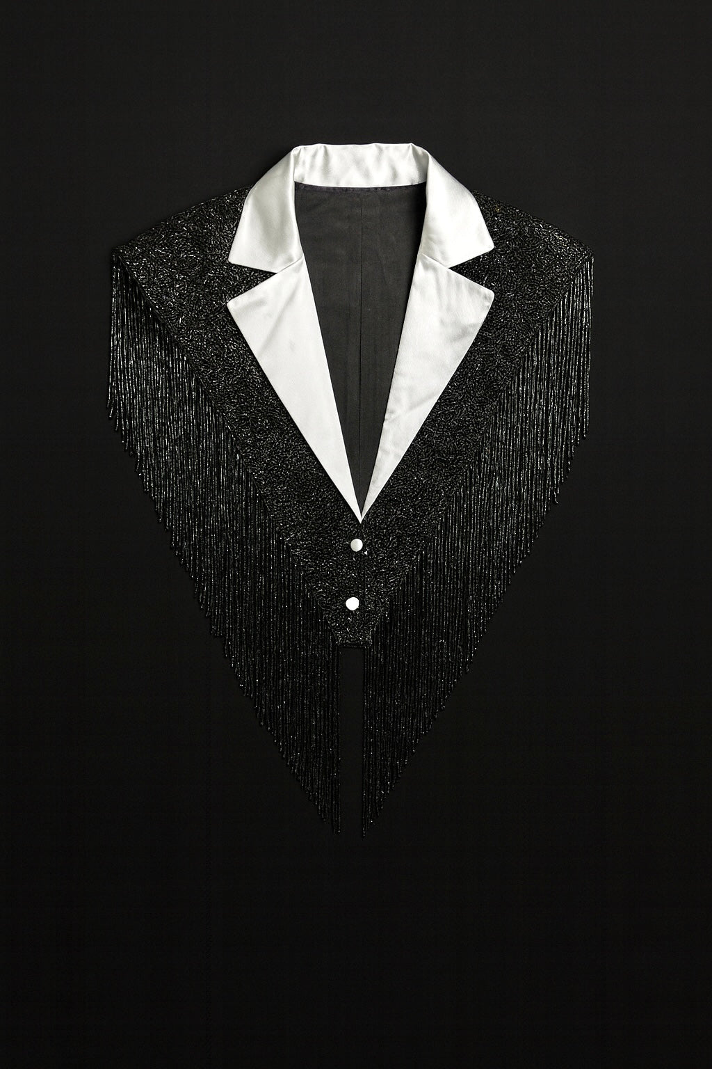 L'Jai Amor The Strategist Cape displayed on a hanger, featuring a stylish, elegant black cape with a smooth fabric finish.