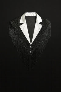L'Jai Amor The Strategist Cape displayed on a hanger, featuring a stylish, elegant black cape with a smooth fabric finish.