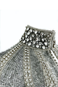 L'Jai Amor Argenté Cascade Cape draped over shoulders, featuring shimmering silver fabric with elegant flowing design.