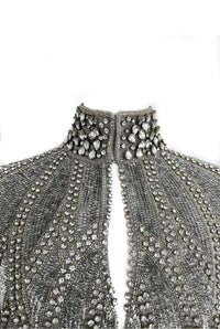 L'Jai Amor Argenté Cascade Cape draped over a mannequin, showcasing its elegant silver fabric and flowing design.