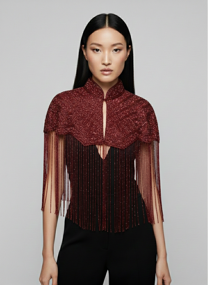 L'Jai Amor Bordeaux fringe cape with intricate fringe detailing and flowing fabric, stylish accessory for elegant outfits.