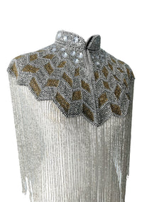 L'Jai Amor Gilded Halo Cape displayed on a mannequin with intricate gold detailing and flowing fabric.
