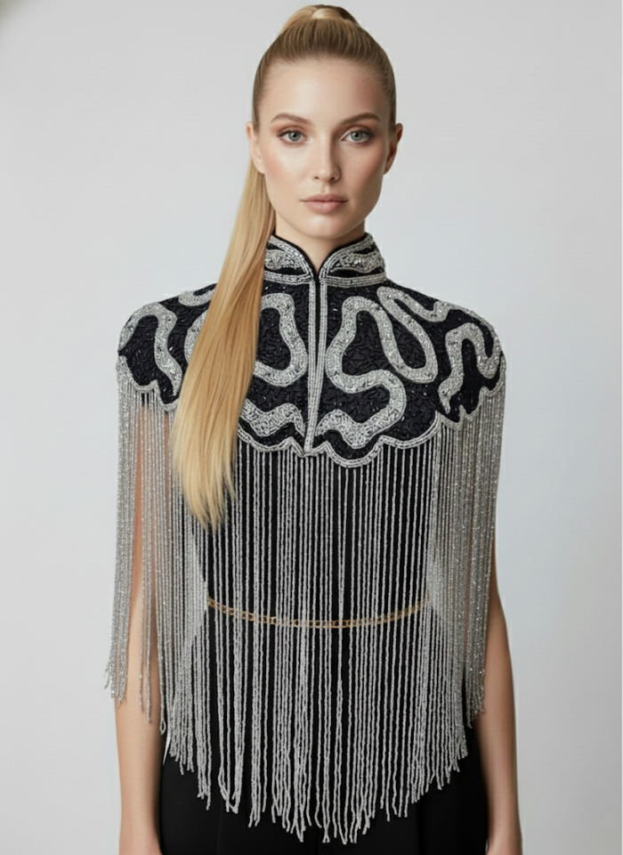 L'Jai Amor Noir Sovereign Cape in luxurious black fabric with elegant draping and detailed design.
